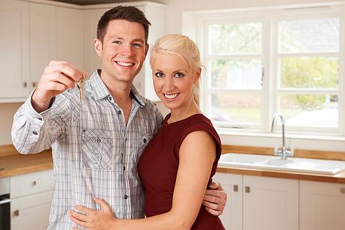 Couple in kitchen with keys to property